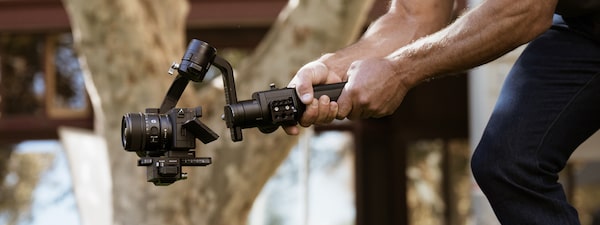 Foto de un hombre grabando un video con la cámara en un estabilizador