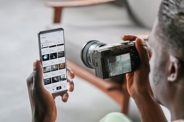 Imagen de un hombre transfiriendo fotos de la cámara a un smartphone