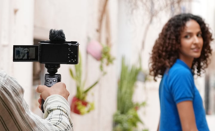 Imagen de uso de un hombre sosteniendo la cámara para fotografiar a una modelo femenina