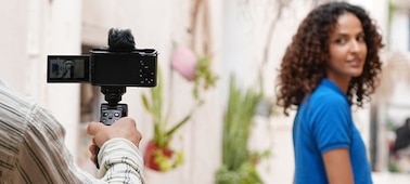 Imagen de uso de un hombre sosteniendo la cámara para fotografiar a una modelo femenina