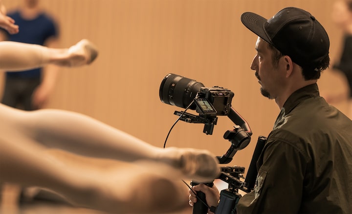 Imagen de uso en la que se muestra un fotógrafo que hace capturas en un ensayo de ballet con una cámara montada en un estabilizador