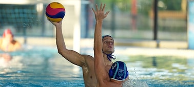 Imagen de producto en la que se muestra a un hombre que intenta arrojar la pelota en un partido de waterpolo mientras otro hombre que está delante defiende extendiendo la mano, pero el enfoque se mantiene en el hombre de atrás