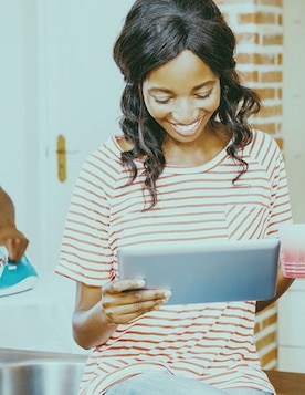 Una mujer en casa mirando una tablet